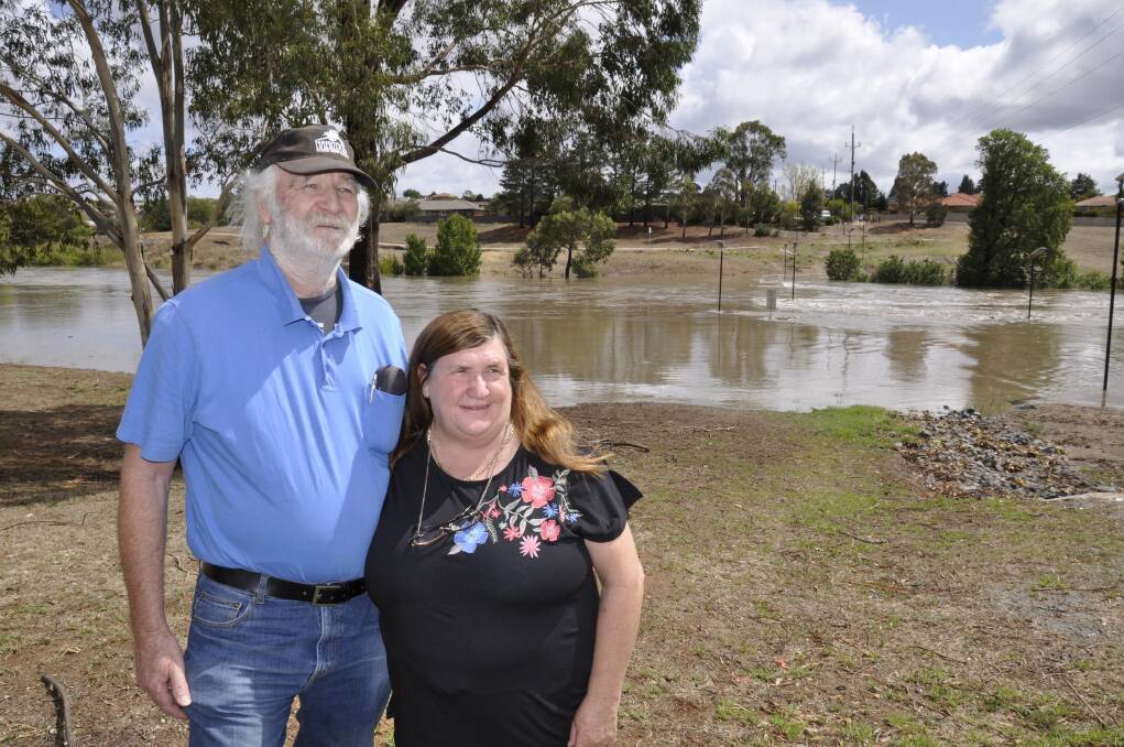 Michael and Anne Carrigg watched the Wollondilly River wash over the Gibson Street bridge behind. Photo: Louise Thrower.