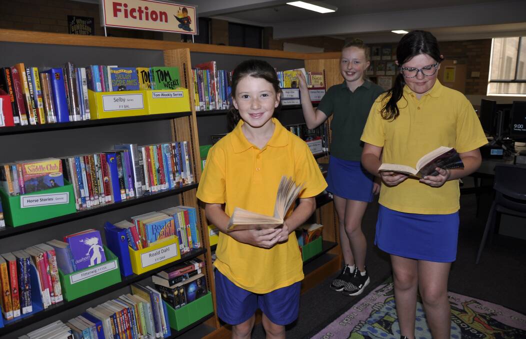 COMFORTABLE: Saint Joseph's Primary School Year 6 students Mia Rae, Mychaela Grealy and Tamia Corby enjoy the air-conditioned library. Photo: Louise Thrower.