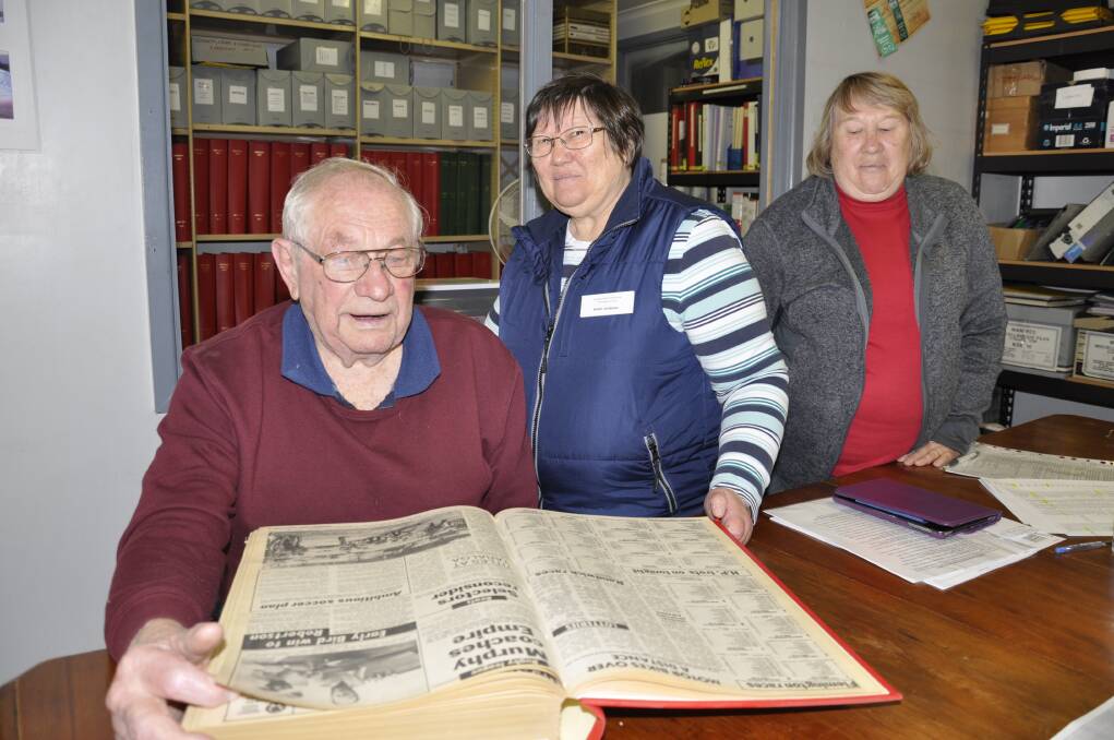 VALUABLE RESOURCE: Goulburn and District Historical and Genealogical Society committee members Garry White and Helen Condylios, with volunteer Pat Rice, peruse old copies of The Goulburn Post. Photo: Louise Thrower.