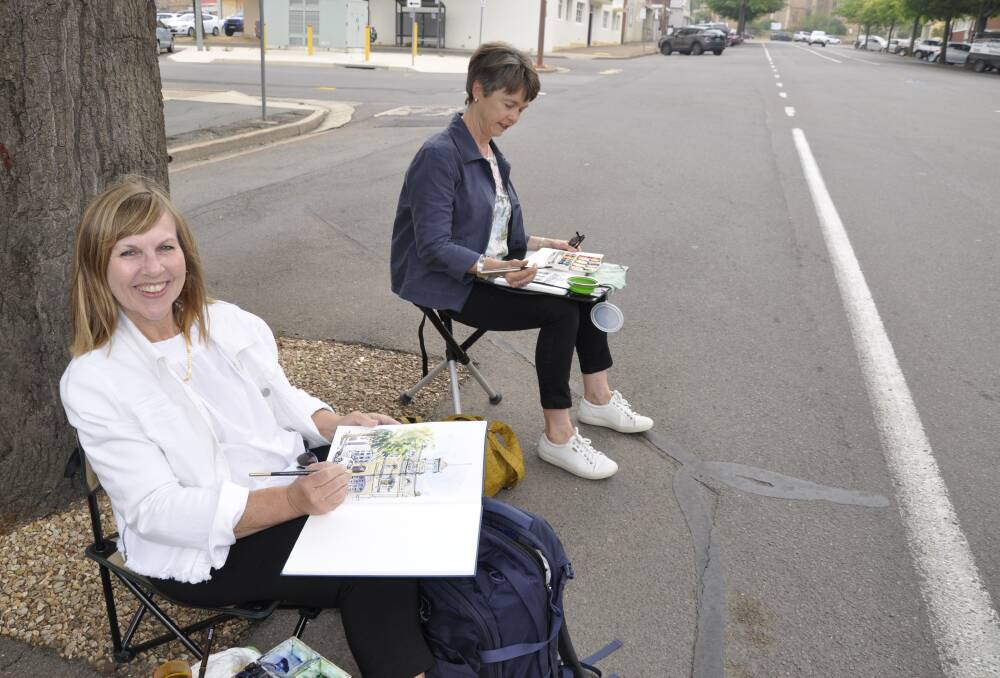 Judy Salleh, of Sydney and Sally Black, of Canberra, took a front row seat on Montague Street on Friday to paint one of the street's landmark buildings.