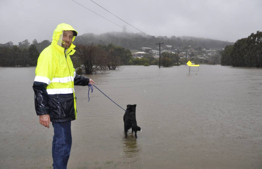 SWAMPED: Daniel Moor and dog, Bowie, checked out the level on May Street where water had covered the new bridge under construction. A site office was also partly immersed. Photo: Louise Thrower.
