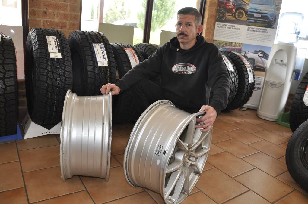 Mick and Joes Tyrepower owner, Damien McAlister, shows two wheels damaged on Braidwood Road in recent days. Replacement of the wheels and tyres cost $1115. Picture by Louise Thrower. 