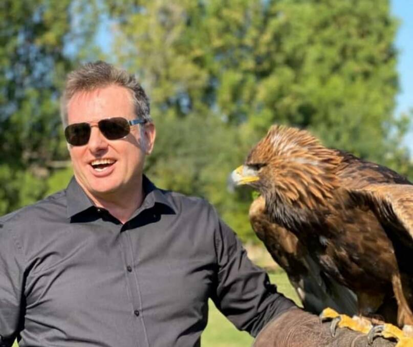 AFFINITY: Mr Husband had a fascination with animals and birds from a young age. Here he holds a trained golden eagle. Photo: Supplied.