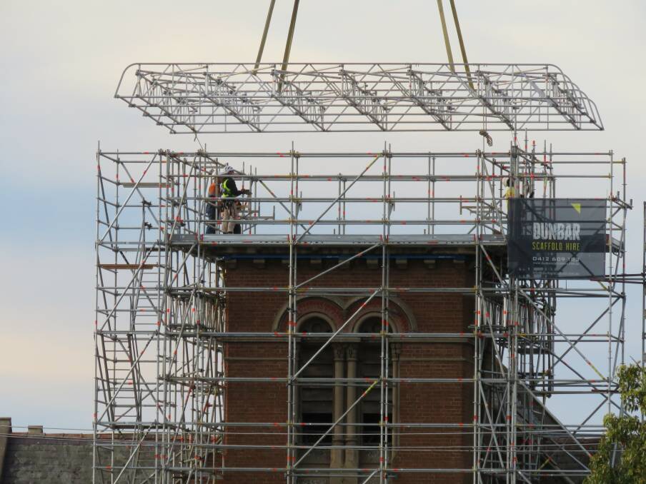 STEADY AS SHE GOES: Workers helped guide a steel roof cap lowered on to Goulburn's Uniting Church last week. Photo: Lyn Terrey.