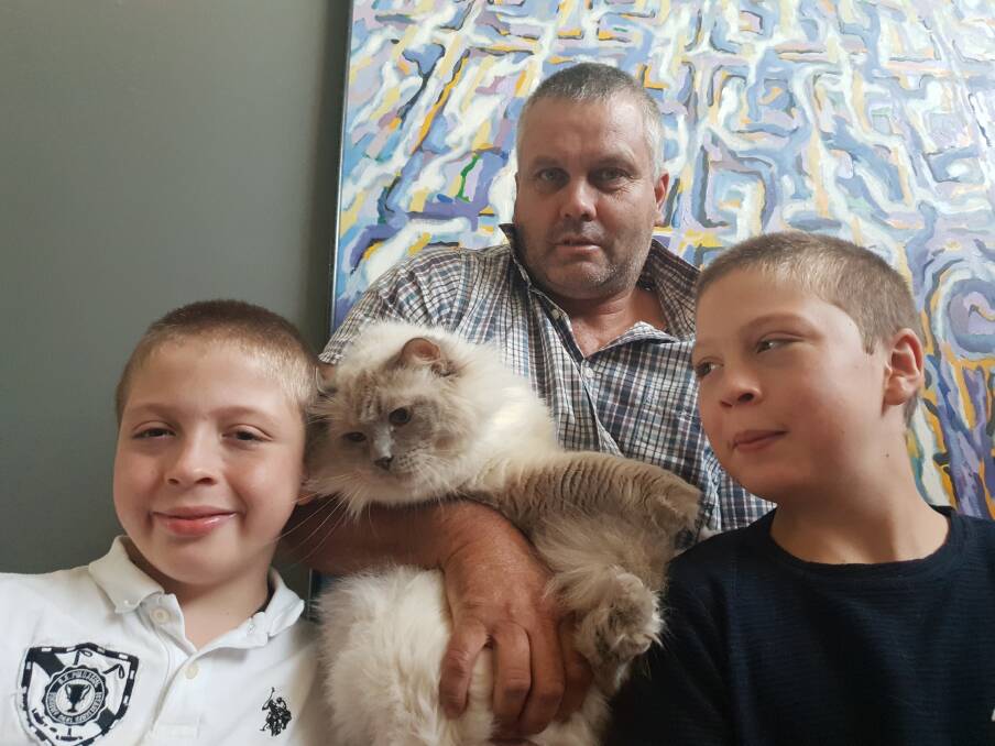 SAVIOUR: Boccy the cat with twins Callan and Hayden, and Garry Bouwens. Photo supplied