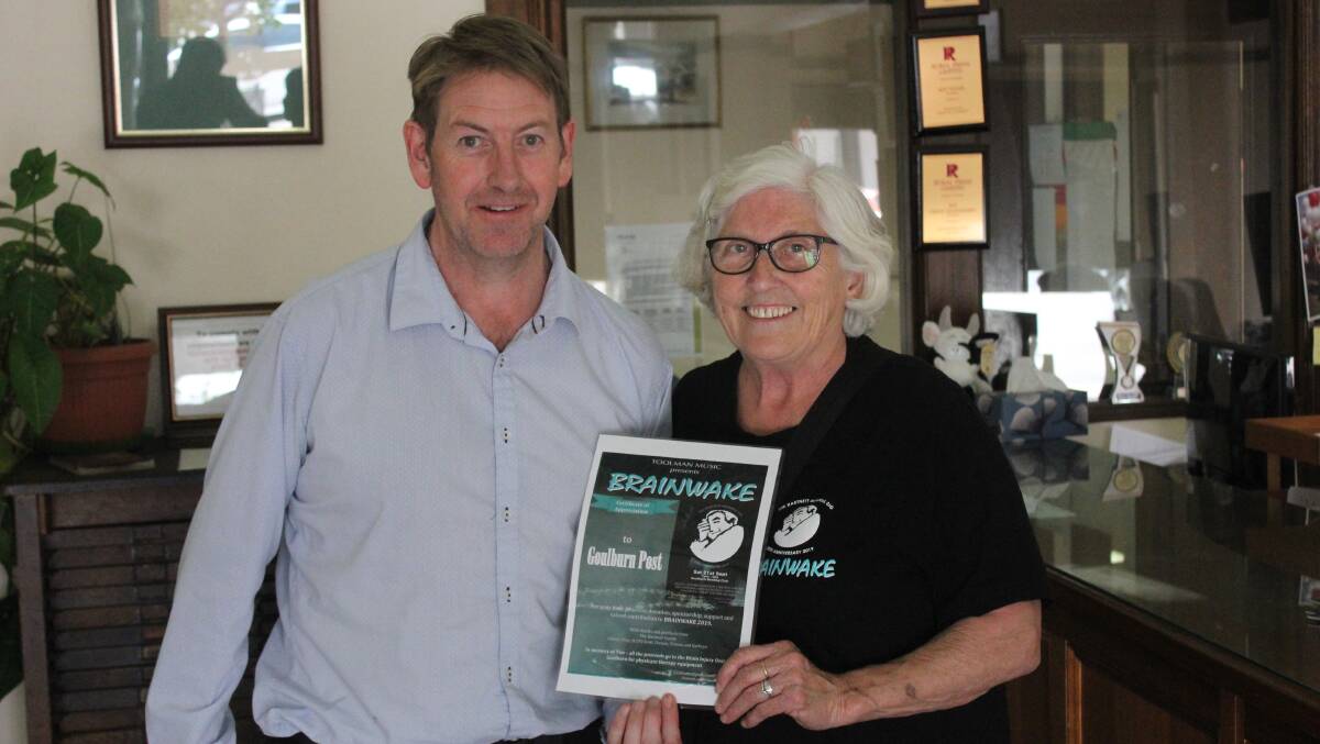 Goulburn Post journalist David Cole receives a certificate of support from Cheryl Hartnett for the Goulburn Post's support of the event. 