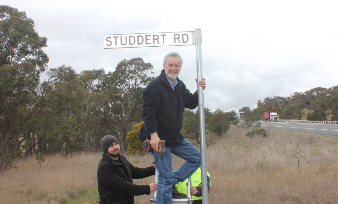 HONOUR: Andrew Studdert installs the road sign with his family's name on it with his son Sam.