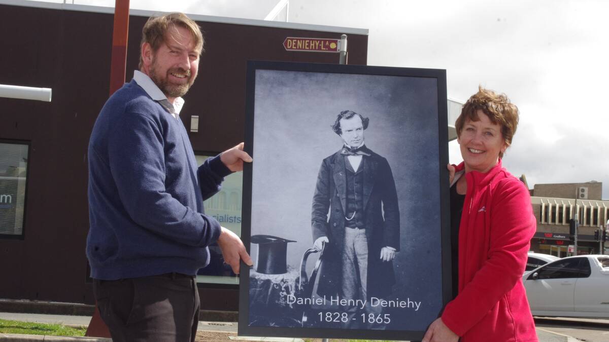 LOCAL CONNECTIONS: Goulburn Post journalist David Cole and Dr Ursula Stephens hold up a portrait of Daniel Deniehy in front of "Deniehy Lane" which runs behind the Goulburn Post. Photo Darryl Fernance. 