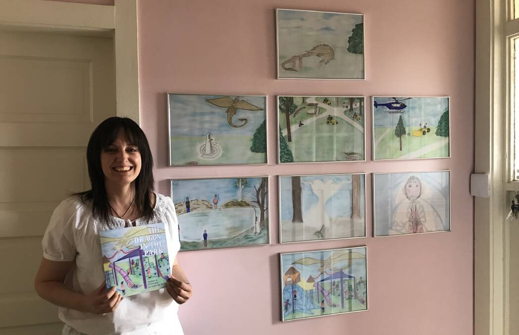 Helen Buck with all of the illustrations in the book as separate paintings. 