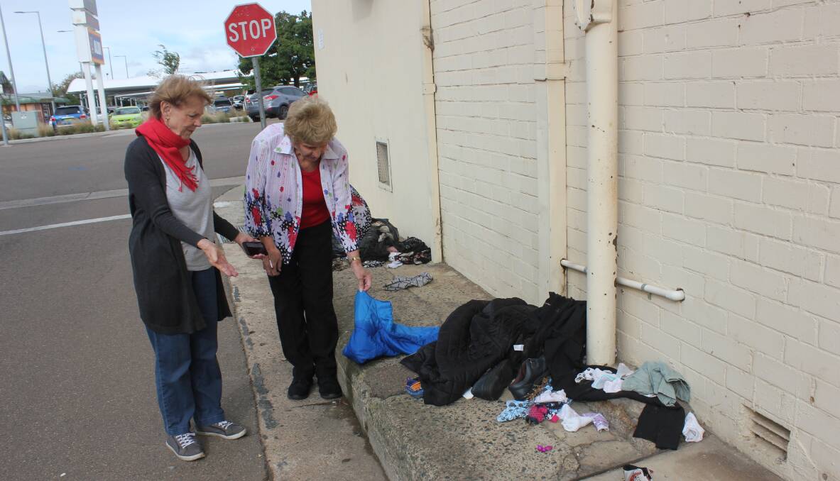 RUBBISH: St Vincent de Paul Goulburn assistant secretary Ruth Vial and president Wendy Wise inspecting some of the rubbish left in the laneway at the back of their Verner Street premises on Monday. Photo David Cole. 