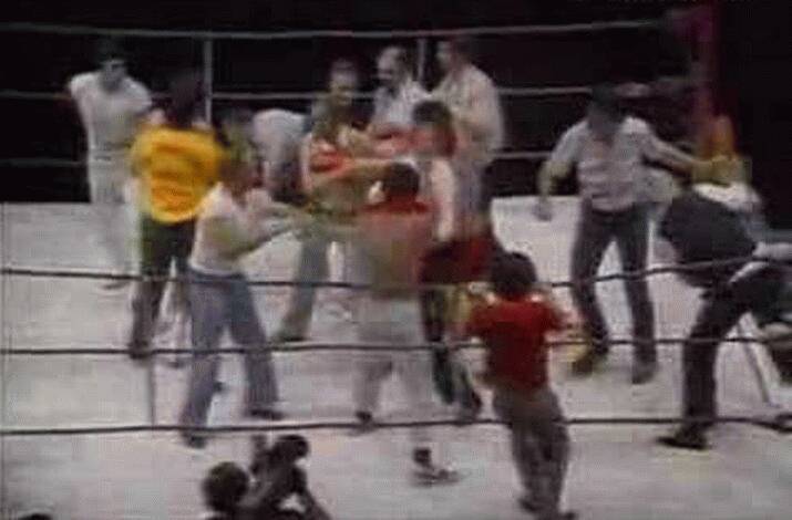 Chaos in the ring as punches fly and both corners and members of the crowd enter the ring.