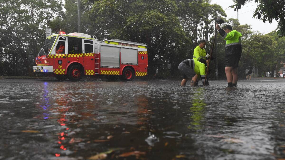 Council workers clear a drain on Railway Terrace in Lewisham during heavy rainfall in Sydney. Photo: AAP Image/Dean Lewins 
