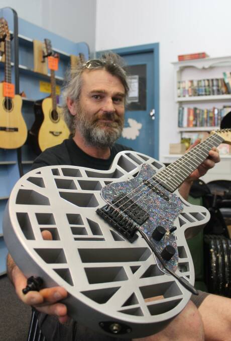 READY TO ROCK: 3DGT Guitars owner Nathan Hughston holds a guitar he designed that was made with his 3D printing technology. 
