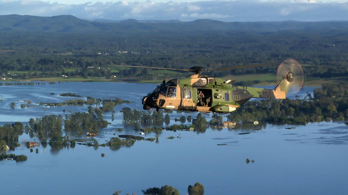 MISSION: A Royal Australian Navy MRH-90 Taipan multirole helicopter flies over flood affected waters during the ADF support to Operation NSW Flood Assist. Photo: Defence
