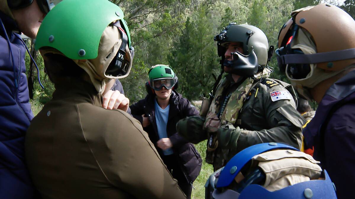 INFO: An 808 Aircrewman gives a safety brief to rescued hikers during Operation NSW Flood Assist. Photo: Defence