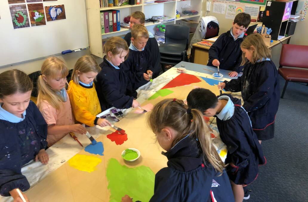 ART: Students at Crookwell Public School create a mini mural for the parklet in Crookwell. Photo supplied