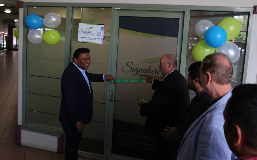 The Signature Training CEO holds the ribbon tight for Mayor Peter Walker at the official opening. 