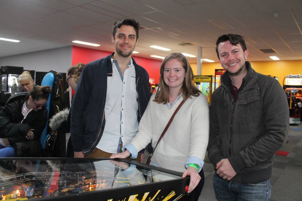 Playing the classics: Alex Corey, Katherine Licleiss and Pat Feeney enjoying one of several pinball machines you can play at Back to the Arcade. Photos: Supplied.