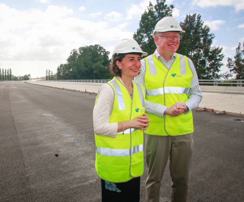 ALL SMILES: NSW Premier Gladys Berejiklian and Kiama MP Gareth Ward check out the 610 metre bridge in Berry. The Berry bypass will be completed before Christmas this year, six months ahead of schedule. Picture: Georgia Matts