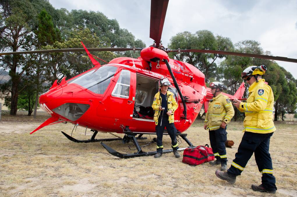 NSW Rural Fire Service rapid aerial response team members Bruce Davies, Jason Hooper and Michael James prepare for their next run to the bushfire areas. Picture: Elesa Kurtz