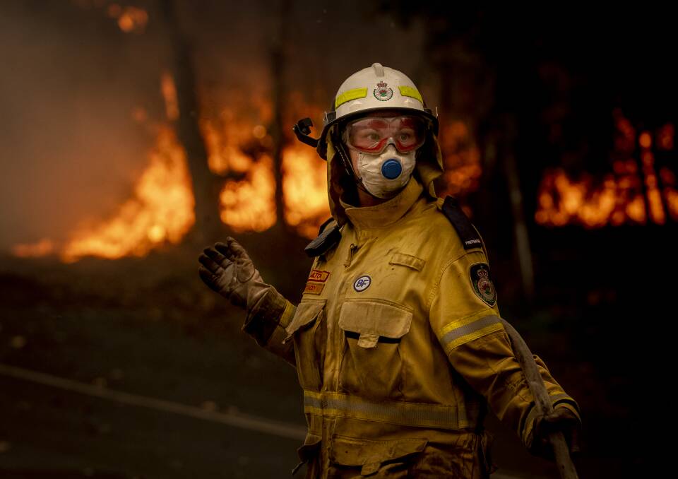 A NSW Rural Fire Service volunteer works to battle a bushfire on Murramaranf Road in Bawley Point on Thursday afternoon. Picture: Sitthixay Ditthavong