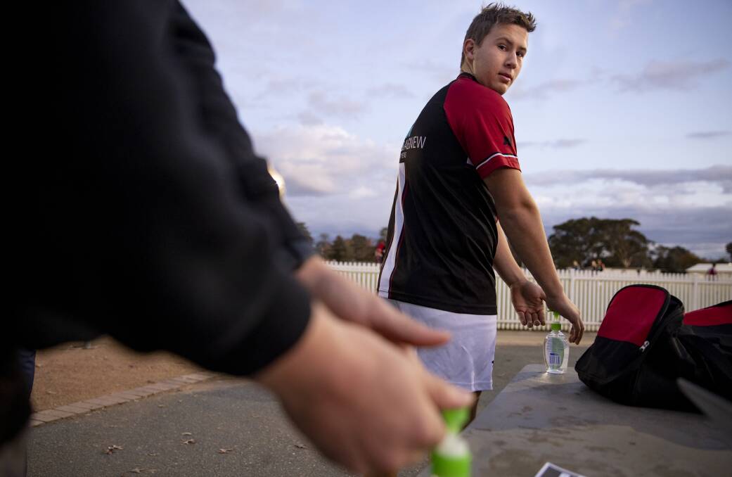 Ainslie Football Club players in Canberra sanitise their hands as they return to training. Picture: Sitthixay Ditthavong