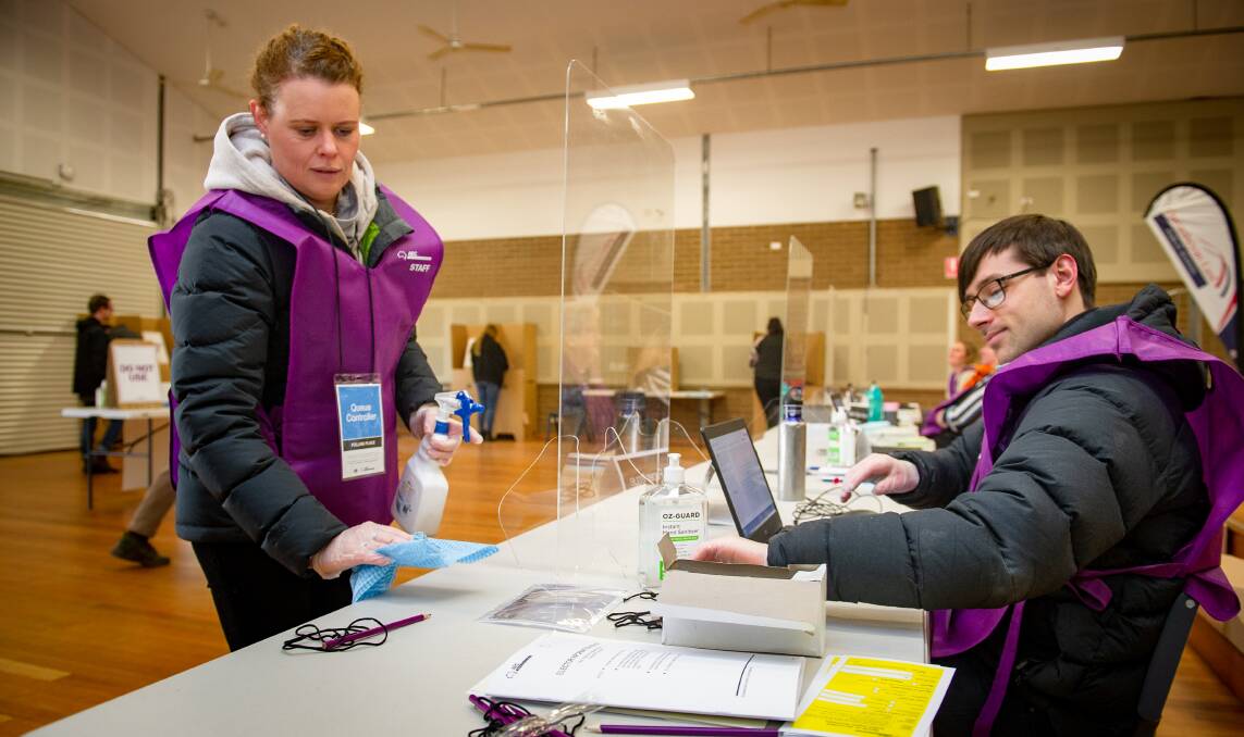 AEC staff members Heather Cross and James Field adhere to COVID-19 guidelines in polling booths. Picture: Elesa Kurtz 