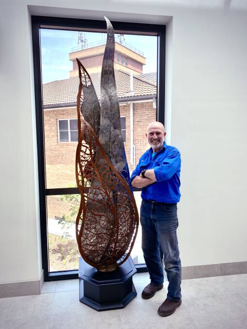 Mark Kelly with his Gum Leaf Trio sculpture in the newly redeveloped Goulburn Base Hospital. Photo: supplied