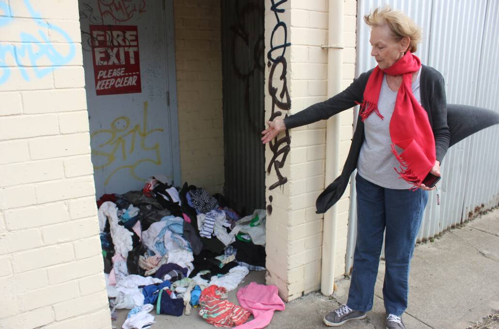 DISGRACEFUL:  St Vincent de Paul Goulburn assistant secretary Ruth Vial inspecting some of the rubbish left in the laneway at the back of their Verner Street premises recently. Photo David Cole