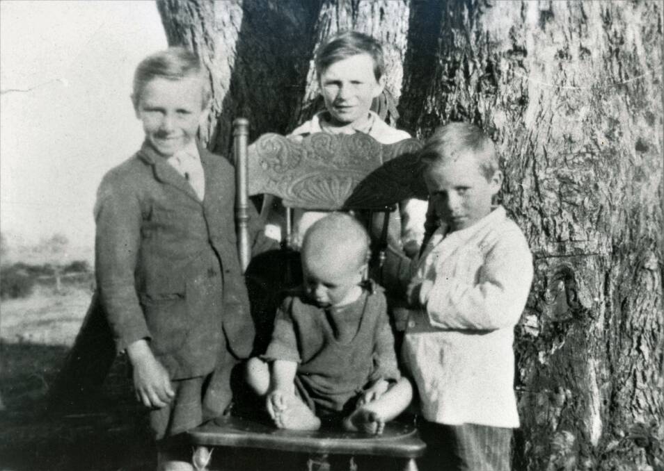 HARD WORKERS: Reg Mahoney, standing behind the chair, with brothers (from left) Hec, Ken and Colin in the 1920s. Their chores involved collecting firewood and looking after younger siblings.