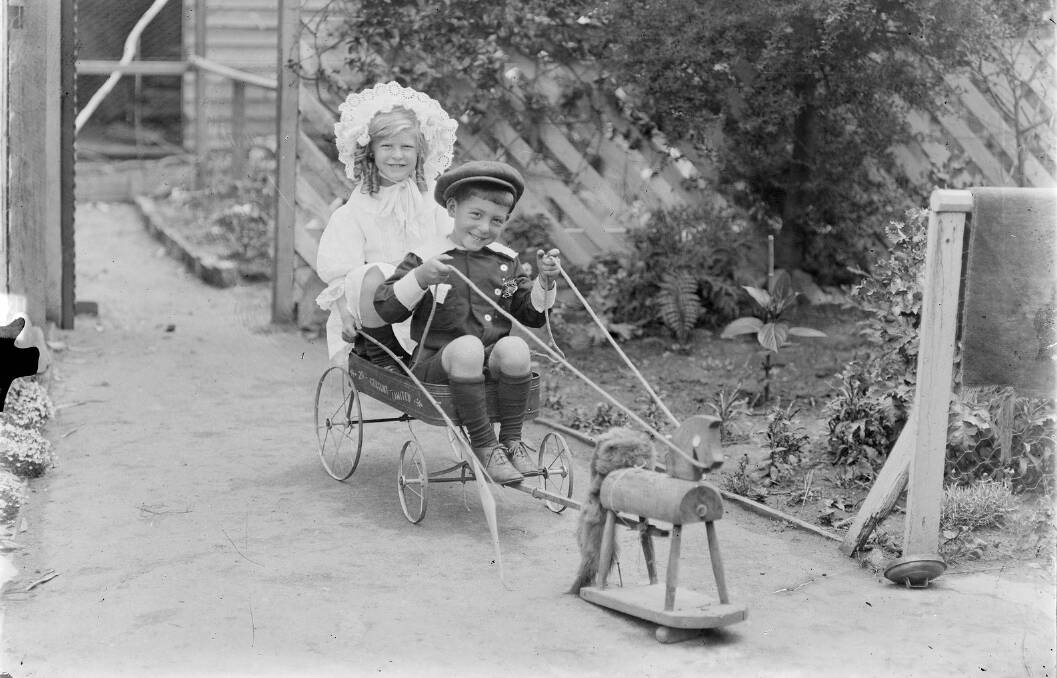 Children in their Sunday best for an outing on a toy wagon with its pretend horse. Photo: State Library of Victoria, H92.206/7