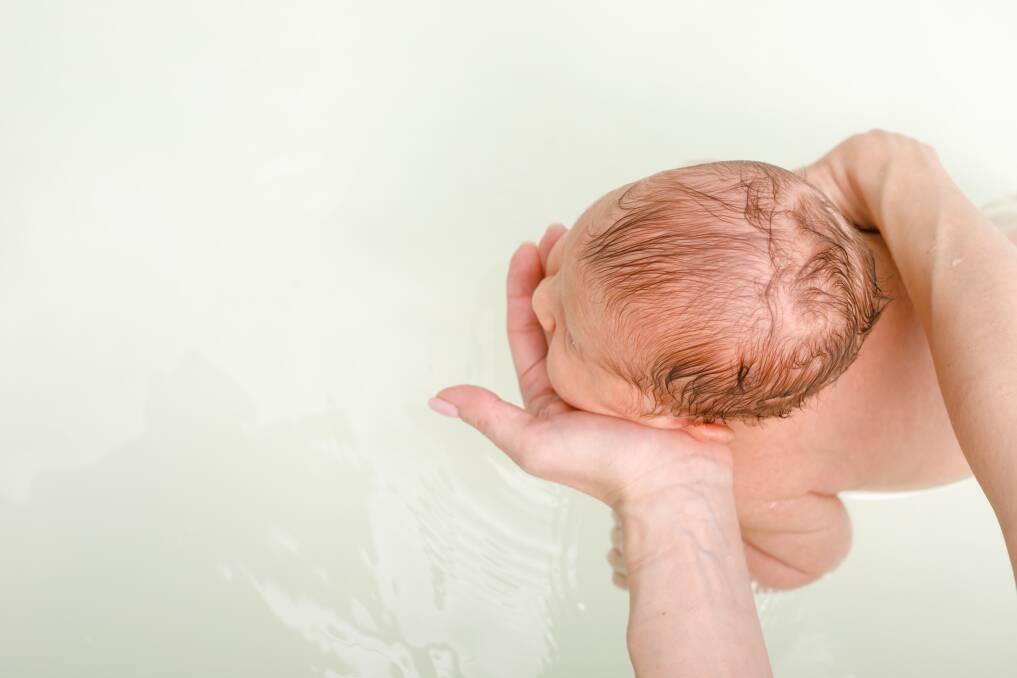 Taylah Gruber is not happy to be bathing her baby in tank water where lead contamination has been detected in the sediment. Photo: Shutterstock.