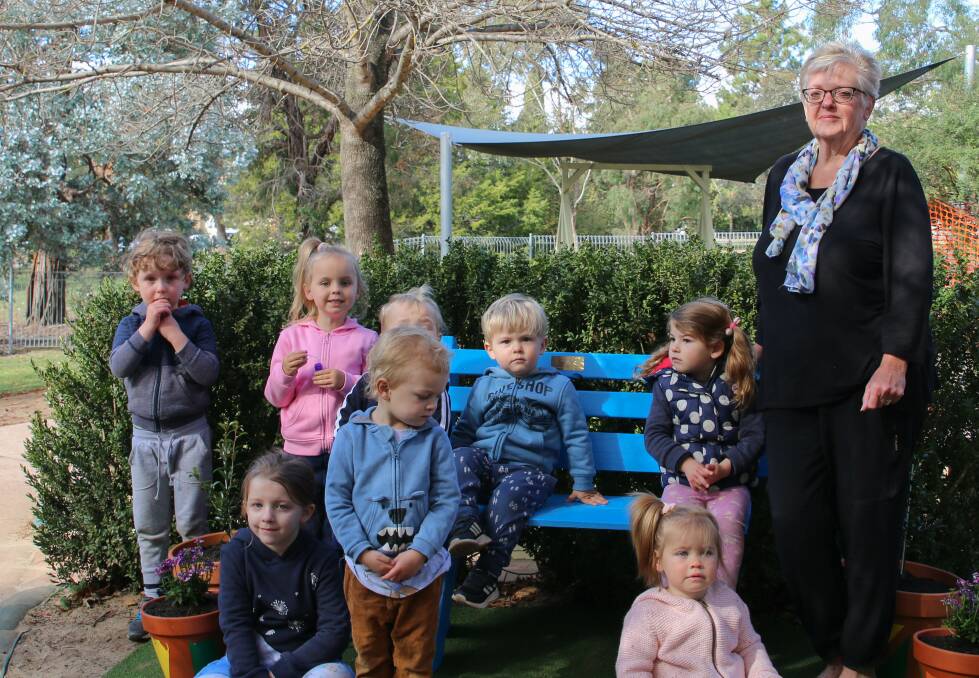MEMORIAL: Some of the centre's children enjoy the bench, following its dedication by Bronwyn Cooper's sister Janelle Storm.