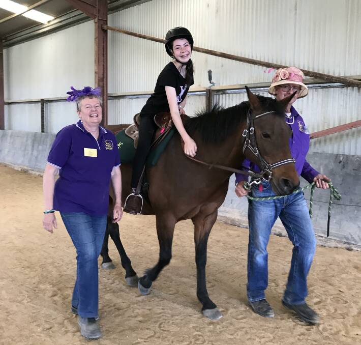 SITTING PRETTY: Volunteers accompany a rider at RDA Goulburn on Melbourne Cup Day last year.