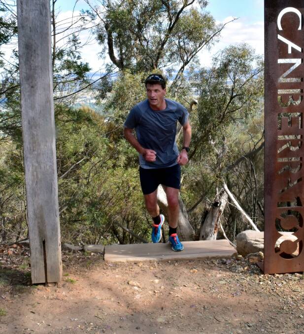 Hard climb: Local MP Angus Taylor cresting Mt Ainslie for the Buzz Lightyears in Canberra recently during the Sri Chinmoy Triple Triathlon. Photo: Supplied.