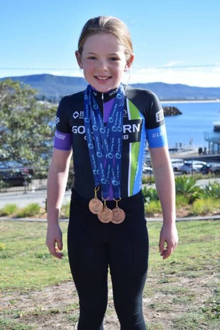 Trifecta: Elsie Apps bears her three medals with a big smile following her latest State Cycling Championship in Illawarra. Photo: Supplied. 
