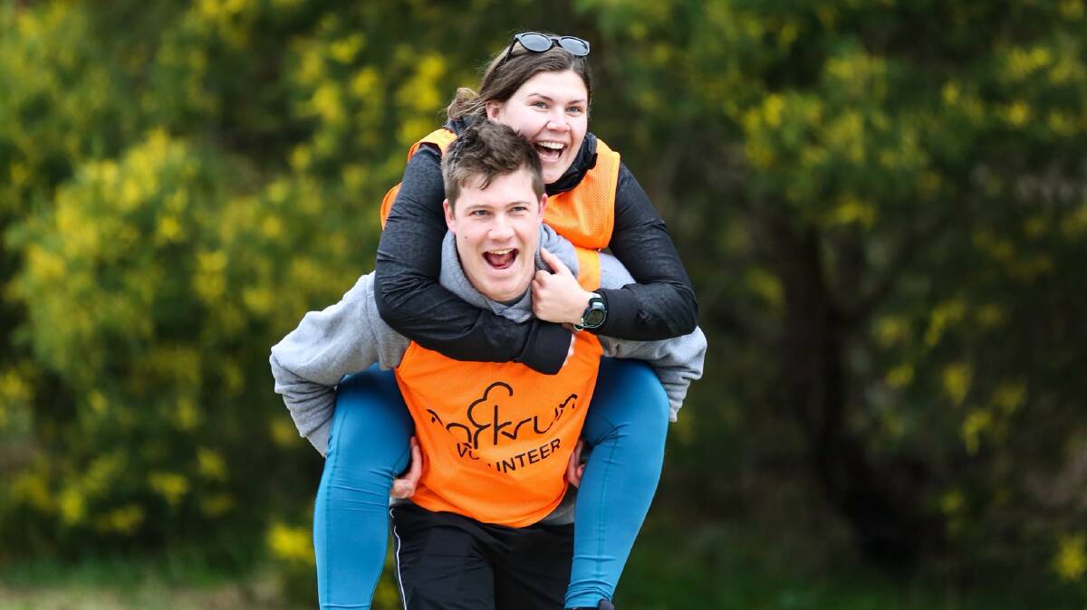 Piggyback: Regular parkrun competitors and volunteers, Claire Stutchbury and Jack Corkill, having a great time out on course during a Parkrun event earlier this year. Photo: Peter Oliver. 