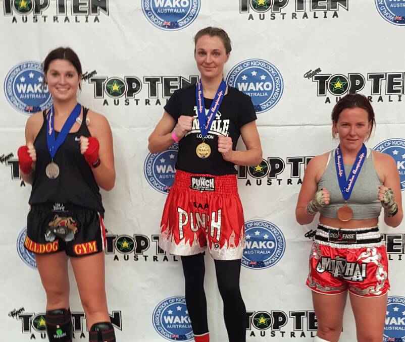 Fast learner: Amy Kolosque (centre) with her first Australian National WAKO Kickboxing Championship gold medal. Photo: Supplied.