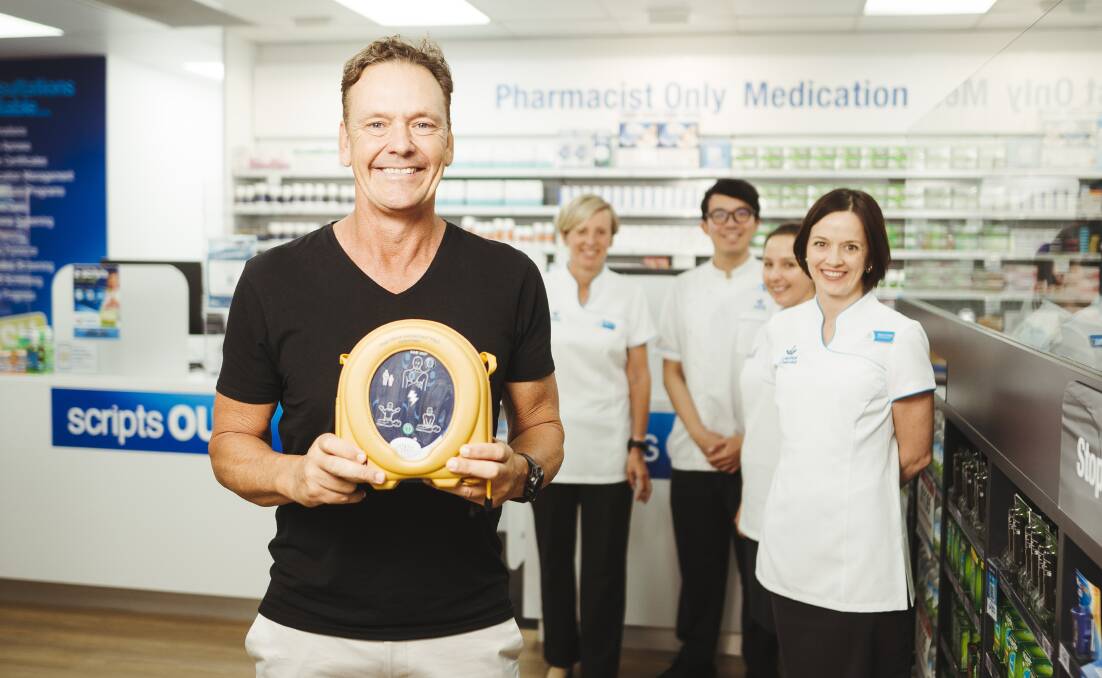 Former Ironman and founder of Heart180 Guy Leech pictured with Rebecca Young owner of Capital Chemist Chisholm as part of his defibrillator rollout. Picture: Dion Georgopoulos