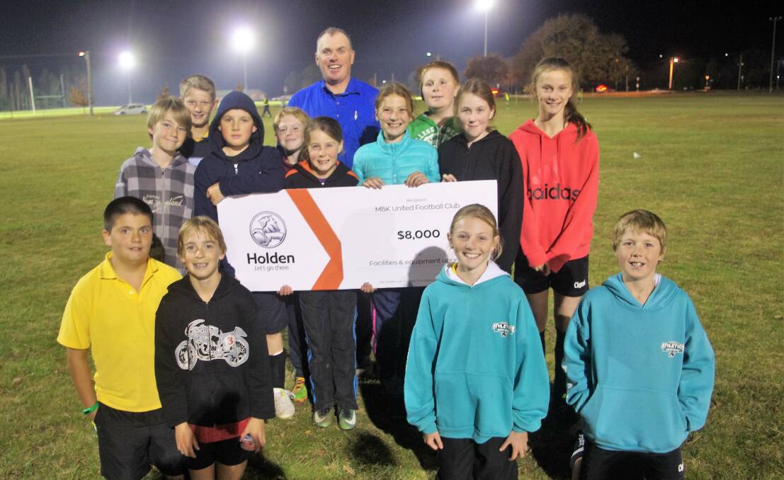 MBK United soccer players and club president Chris Webb with the Geissler Motors cheque that has helped purchase goalposts and other equipment. Photo: Darryl Fernance