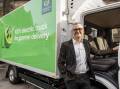 Woolworths chief executive Brad Banducci with an electric delivery truck. (HANDOUT/WOOLWORTHS)