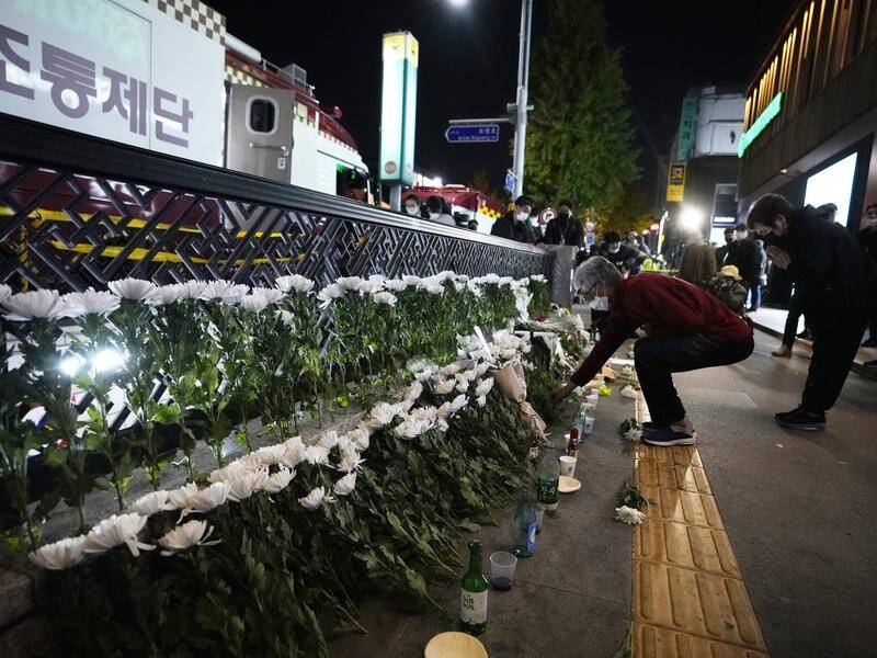 Tributes are left near the scene of a deadly accident in Seoul where 153 mostly young people died. (AP PHOTO)