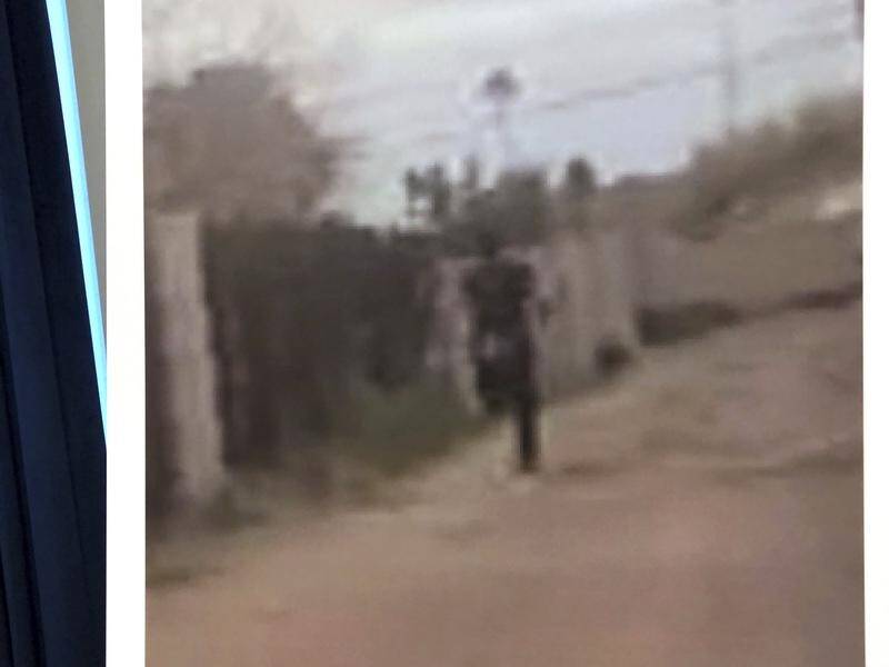 A still photo from the officer's body camera shows a teenage suspect running away before being shot.