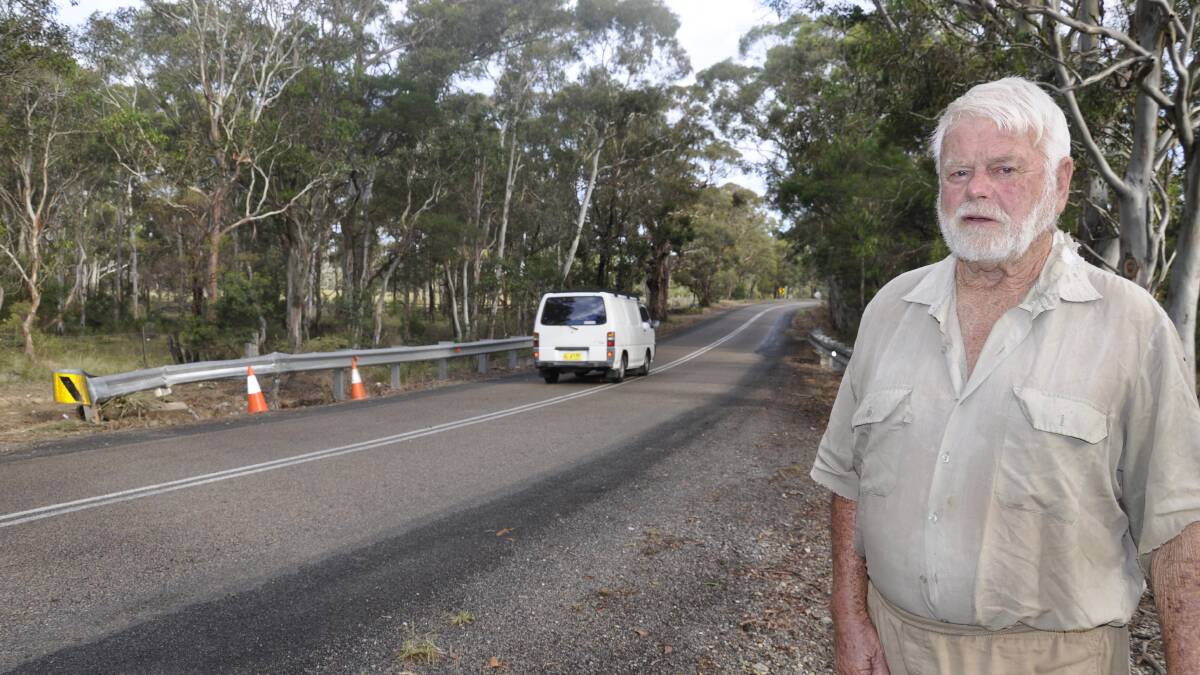 NOT AGAIN: Jerrara Rd resident Ross Goddard says motorists need to drop their speed along the thoroughfare between South Marulan and Bungonia. Behind him, a car crashed into a guardrail on Friday, injuring a woman and her daughter. The cause is unknown at this stage. 