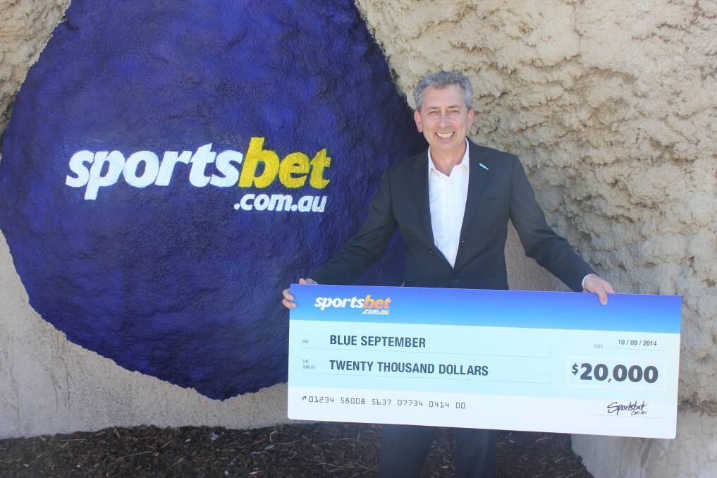 Blue September Campaign Manager Mike Chapman holds the cheque for $20,000 donated by Sportsbet. 