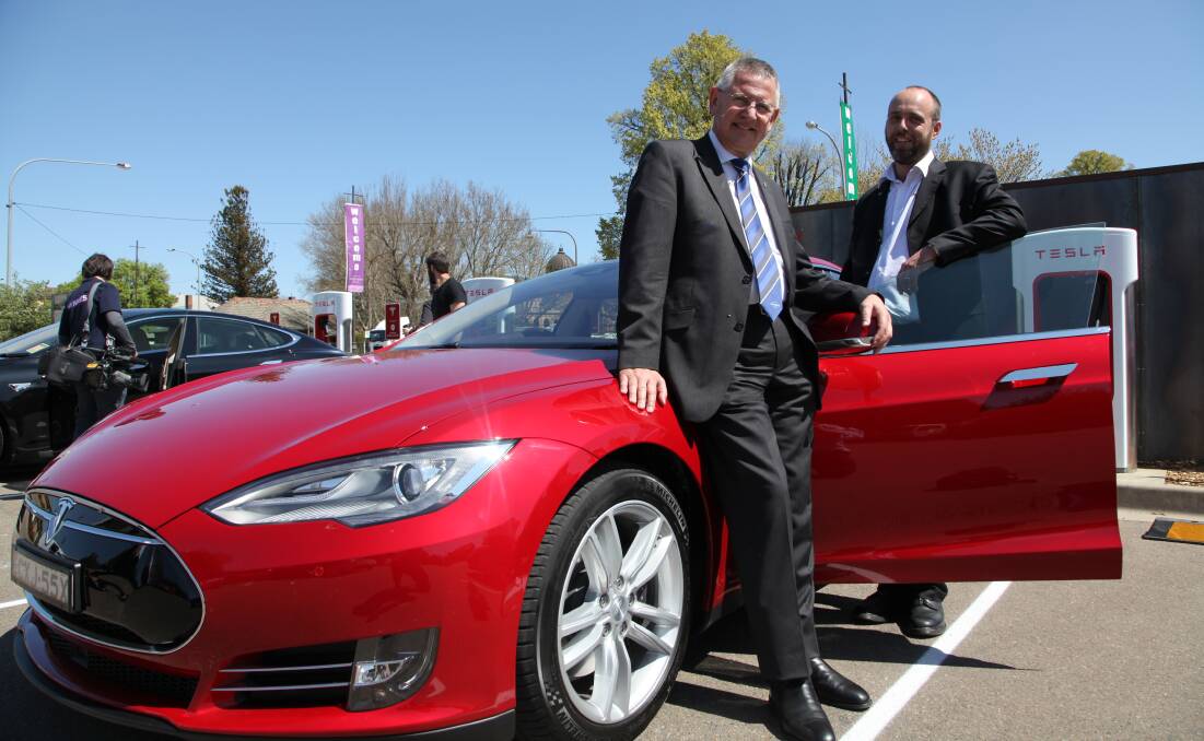 BRIGHT SPARKS: Goulburn Mulwaree mayor Geoff Kettle and Tesla Australia’s Supercharger Program Manager Evan Beaver at the Goulburn Supercharger on Thursday. 