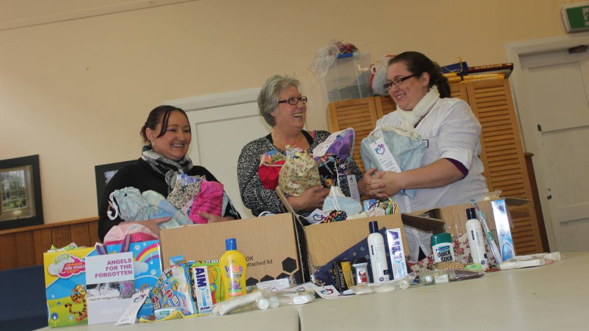 SHARING’S CARING: Drop In Centre volunteers Jody Lovich and Sue Robinson accept toiletry donations from Angels For The Forgotten founder Melina Skidmore.
