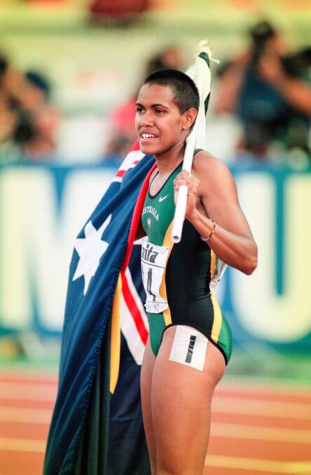 Cathy Freeman carrying the Aboriginal flag and Australian flag at the World Track and Field Championships in Athens in 1997. Picture: Getty Images