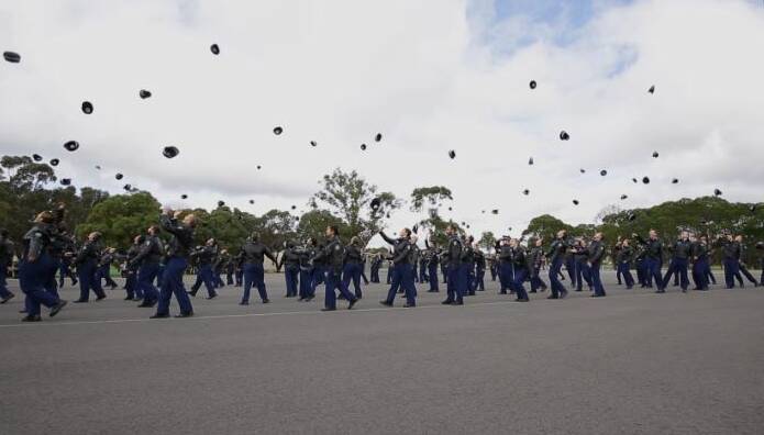 New recruits throw their hats in the air as Class 340 is dismissed.