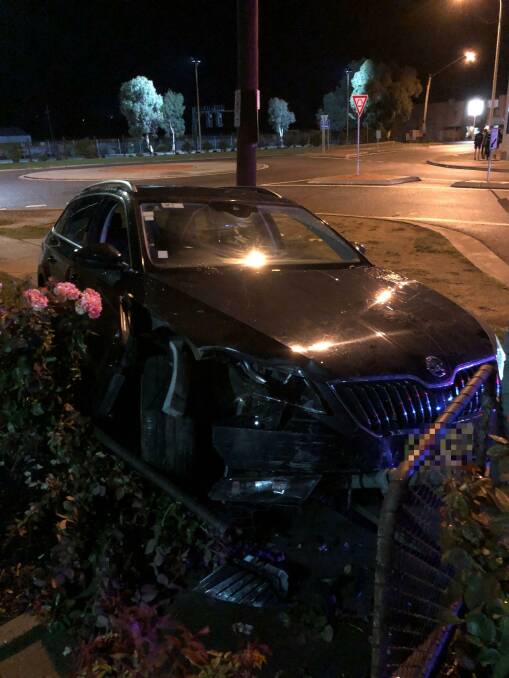 ON SCENE: A black hatchback crashes into a fence and rose bushes at Goulburn Police Station in March. Photo: supplied